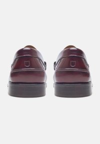 Donker bordeauxleren schoenen met een gladde afwerking, ronde neuzen, een lage gestapelde hak en decoratieve stiksels langs de zijkanten.