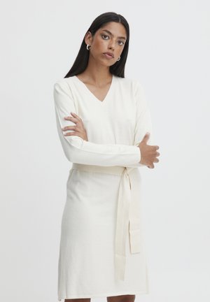 Cremfarbendes, gestricktes Kleid mit V-Ausschnitt und langen Ärmeln, das mit einem passenden Bindegürtel in der Taille und einer glatten Textur versehen ist.