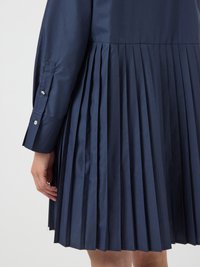 Navy blue dress with pleated skirt and cuffed long sleeves. Smooth fabric with a structured design, featuring small buttons on the cuffs.