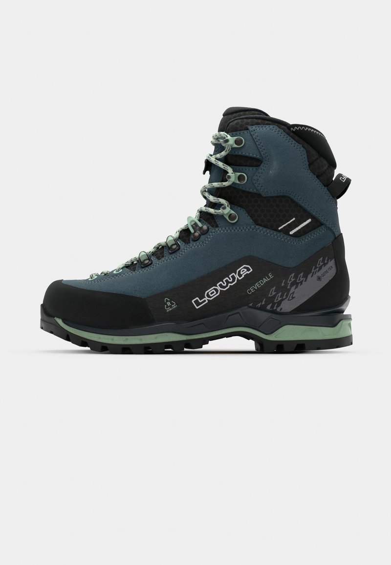 Botas de caminhada em camurça verde-escura com detalhes em preto, apresentando um cabedal texturizado, atacadores verdes e uma sola em borracha preta robusta.