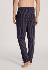 Navy blauwe pyjamabroek met verticale strepen in rood en wit, elastische tailleband, lichtgewicht stof en rechte pijpen.