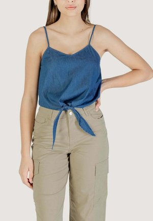 Top senza maniche in denim blu con scollo a V e nodo frontale, abbinato a pantaloni cargo beige con tasche laterali e vestibilità comoda.