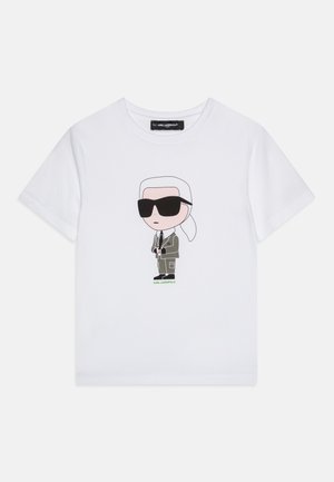 Biały T-shirt z krótkim rękawem z postacią z kreskówki z białymi włosami, czarnymi okularami przeciwsłonecznymi, szarym garniturem i napisem „KARL LAGERFELD” poniżej.