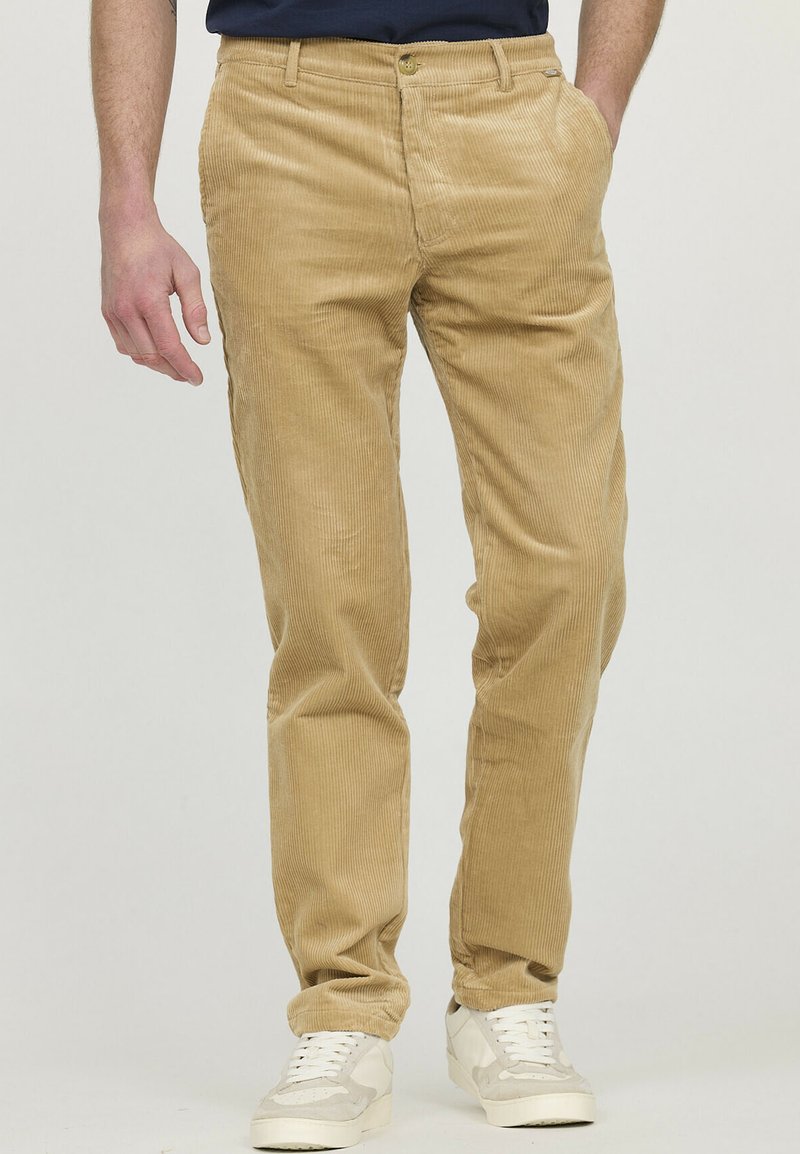Pantalons en velours côtelé beige avec texture à côtes verticales, coupe droite, deux poches latérales et fermeture à bouton à la taille.