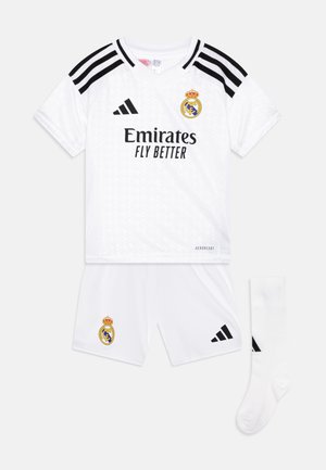 Witte Adidas voetbaloutfit bestaande uit een kortwerkmouwenshirt met zwarte accenten, het logo "Emirates Fly Better", bijpassende shorts en een witte sok.