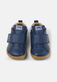 Granatowe skórzane buty z rzepem, brązowa gumowa podeszwa, zaokrąglony czubek i akcenty z tkaniny. Na pięcie znajduje się logo "Camper".