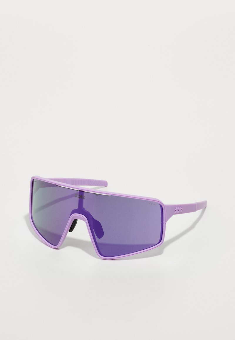 Lunettes de soleil violettes avec une grande lentille en forme de visière et des montures épurées. Le design présente une finition brillante et un logo discret sur le côté.