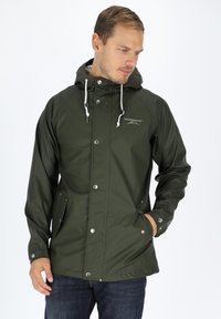 Dark green rain jacket with a hood, snap buttons, white drawstrings, and side pockets. Features a logo in the upper left area.
