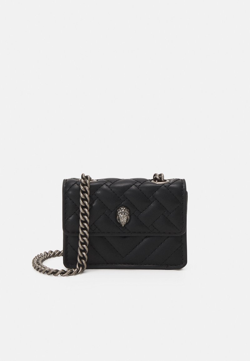 Borsa a tracolla nera trapuntata con catena in argento e un accento decorativo sulla parte anteriore. Presenta una forma rettangolare compatta.