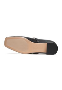Zwarte platte schoen met puntige neus, beige zool met textuurgreep en een kleine zwarte hak, maat 39 gemarkeerd op de zool.