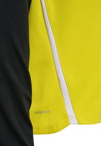 Close-up van geel-zwarte sportstof met witte streep en "BEECOOL" logo in kleine grijze letters bij de zoom.