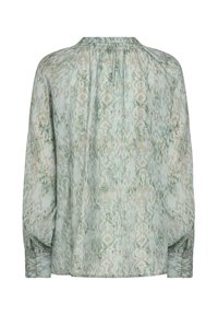 Loose-fitting, long-sleeve blouse in a soft green fabric with a subtle abstract pattern in gold and cream. Features gathered neckline and cuffs.