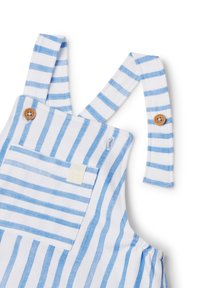Peto de algodón a rayas azul y blanco con tirantes, detalles de botones de madera y un bolsillo frontal que presenta una pequeña etiqueta.
