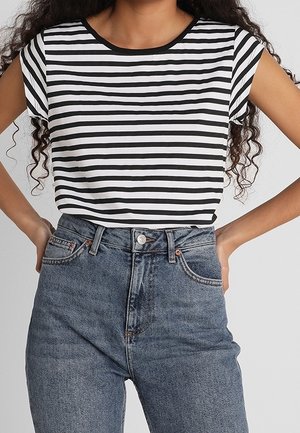 Czarna i biała koszulka w paski z krótkim rękawem i okrągłym dekoltem, zestawiona z wysokim stanem niebieskich dżinsów.