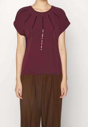 Burgundy short-sleeve top with a round neckline, featuring black sequin accents arranged in vertical lines on the front. Smooth fabric texture.