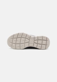 Semelle de sneaker légère en caoutchouc texturé, de couleur grise, avec des canaux de traction à motifs pour une meilleure adhérence.