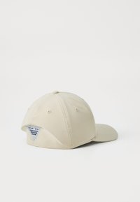 Căciulă de baseball bej cu o margine curbată, design cu șase panouri și un patch cu logo PFG pe spate. Textura materialului este netedă și durabilă.