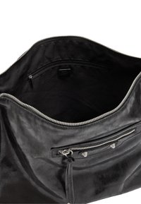 Czarna skórzana torba o gładkiej fakturze, z główną komorą zapinaną na zamek oraz mniejszą przednią kieszenią na zamek z akcentami w postaci ćwieków.