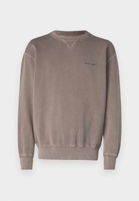 Brun sweatshirt med rund halsringning, ribbade mudd och nederkant, med en liten, ton-i-ton logotyp på bröstet och en subtil texturerad yta.