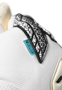 Witte sneaker met textuur in meshstof, zwarte geometrische accenten en een teal logo patch. Het ontwerp heeft stijlvolle rondingen en gedetailleerde stiksels.