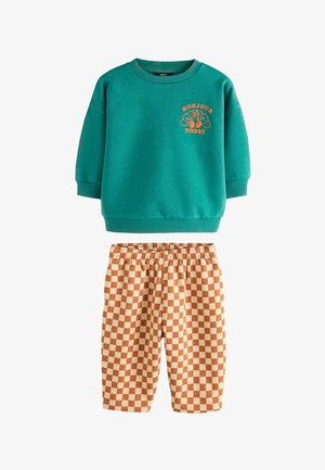 Turkizna dukserica z oranžnim napisi "BONJOUR TODAY" in kariraste oranžno-rjave kratke hlače z elastičnim pasom. Mehak material, sproščen kroj.