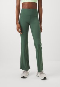 Pantaloni yoga verdi a vita alta realizzati in tessuto morbido, caratterizzati da un design a gamba svasata e una vita elasticizzata per il massimo comfort.
