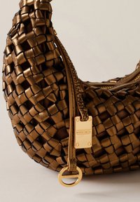 Waren aus braunem, geflochtenem Leder, mit einer runden Form, ausgestattet mit einem goldenen Hardware-Tag und einem dekorativen Ring. Texturierte Oberfläche mit aufwendigen Mustern.