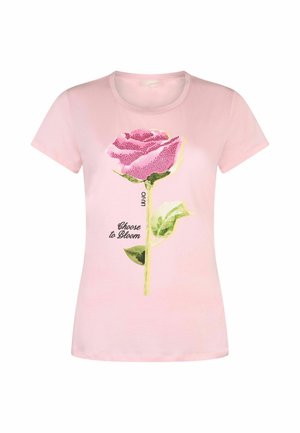 Maglietta a maniche corte di colore rosa chiaro con una grande rosa rosa e foglie verdi come grafica, con la scritta "Scegli di Fiorire."