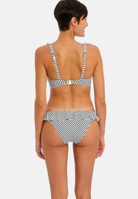 Bikini dengan pola garis hitam putih dan pinggang berkumpul; atasan terstruktur dengan tali yang dapat disesuaikan dan penutup belakang dengan pengait.