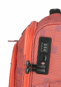 Reise-Rucksack aus strukturiertem Korallmaterial, mit einem Kombinationsschloss, doppelten Reißverschlüssen und einem geometrischen Muster auf der Oberfläche.