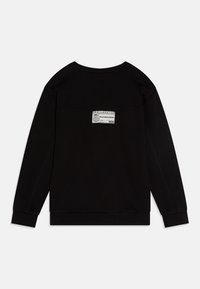 Schwarzes Langarm-Sweatshirt mit gerippten Bündchen und Saum, das auf der oberen Rückseite eine kleine weiße rechteckige Label mit skateboarderbezogenem Text zeigt.