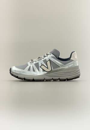 Chaussure de sport grise et argentée avec lacets, dessus en mesh texturé et semelle rembourrée, positionnée de profil sur fond neutre.