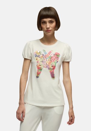 T-shirt bianco a maniche corte con un design di farfalla colorato realizzato in paillettes testurizzate sul davanti. Tessuto morbido con maniche a sbuffo.