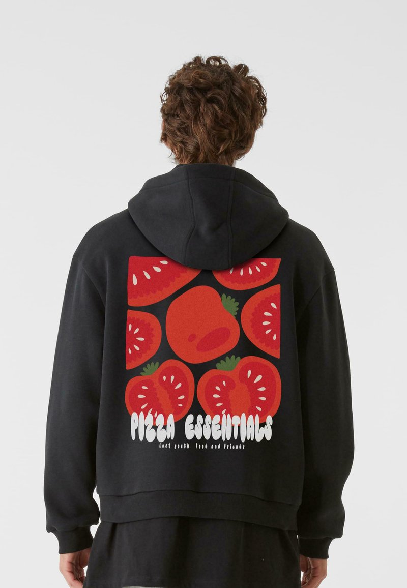 Fekete kapucnis pulóver, színes grafikával a hátsó részén, amelyen piros paradicsomok, zöld kiegészítők és a "Pizza Essentials" felirat látható fehér színben.