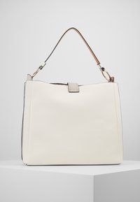 Vit läderhandväska med en strukturerad form, försedd med en lång avtagbar axelrem och en metallkläppdetalj. Slät textur, minimal design.