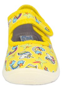 Gelbe Leinenschuhe mit einem Muster aus Einhörnern, Regenbögen und Sternen. Verfügt über zwei Klettverschlüsse und eine weiße Gummisohle. Weicher Stoff.