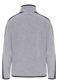 Chaqueta de forro polar gris claro con cuello alto, acentos laterales azul oscuro y ribetes negros en los puños y el dobladillo. Textura suave, diseño casual.