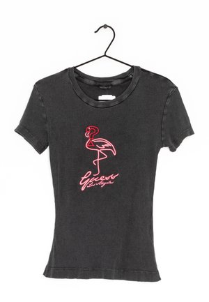 T-shirt gris à rayures avec des manches courtes, ornée d'un flamant rose brodé et du texte "Guess Los Angeles" au centre.