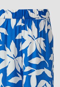 Jupe en tissu bleu avec grand imprimé blanc de feuilles tropicales et lignes verticales texturées, avec une taille élastique.