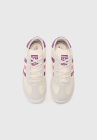 Baskets créme avec des rayures violettes et roses, en tissu texturé, bout rond et lacets. Présente un logo Adidas sur la languette.