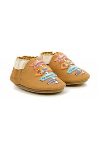 Zapatos de cuero marrón claro con una textura suave, que presentan parches de tela coloridos que muestran destinos de viaje y una banda elástica blanca en el tobillo.