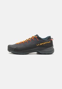 Schwarzer Wanderschuh mit orangen Schnürsenkeln, strukturiertem Obermaterial und blauen Akzenten. Verfügt über eine markierte Seite, Gummisohle und robuste Verarbeitung.