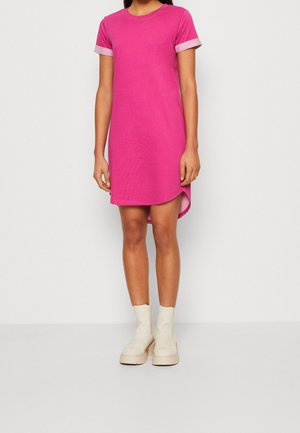Pink cotton dress with short sleeves, round neckline, side slits, and contrasting light pink cuffs. Worn with beige ankle boots.
