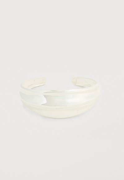 Bracelet manchette en métal argenté poli. Caractérisé par un design lisse et arrondi avec un large bracelet incurvé, ouvert aux deux extrémités pour un ajustement réglable.