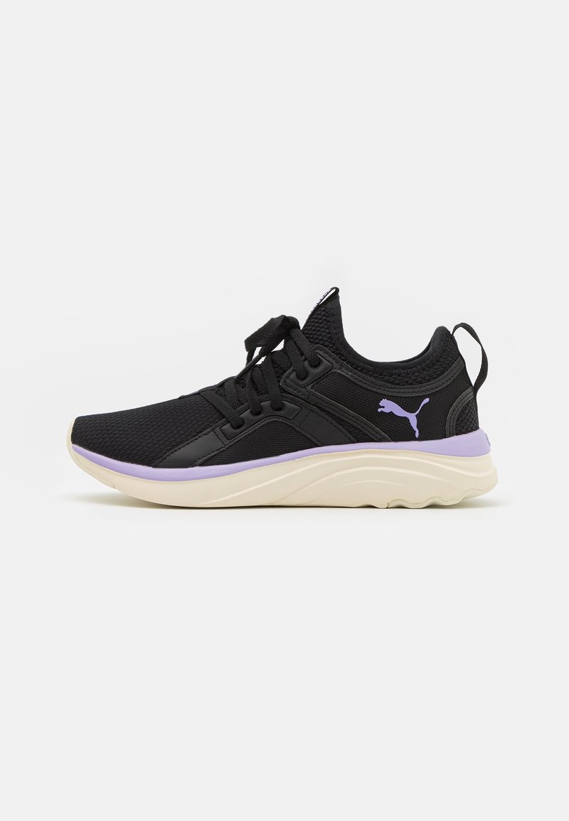Černá sportovní bota s síťovaným svrškem, fialovými akcenty a texturovanou bílou podrážkou. Obsahuje tkaničky a logo na boku.