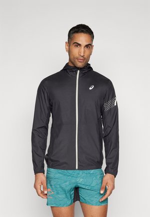 Schwarze leichte Laufjacke mit Reißverschluss, Kapuze und reflektierenden Akzenten; kombiniert mit strukturierten türkisfarbenen Shorts mit einem Muster.