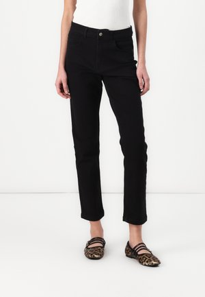 Black cotton jeans with a slim fit, featuring front pockets and a button closure. Paired with leopard print flats.