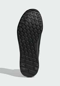 Podeszwa buta wykonana z teksturowanego czarnego gumowego materiału z okrągłymi wzorami grip i napisem z logo "STEALTH" z tyłu.
