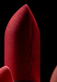 Rossetto opaco rosso con punta appuntita, caratterizzato dal logo del marchio impresso sul lato, su uno sfondo nero.