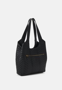 Black quilted tote bag made from textured leather, featuring a chevron pattern and a front zip pocket with gold-toned hardware.